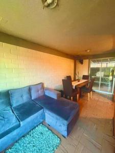 un soggiorno con divano blu e tavolo di Casa 2 habitaciones en Labranza - Temuco a Temuco