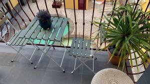 a green chair and a table with a potted plant at Apartamento Los Guirres in Tazacorte