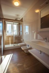a bathroom with two sinks and a toilet and a window at Tre cancelli rooms in Potenza