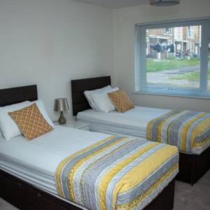 a bedroom with two beds and a window at 2-Bed Sleeps 4 Comfy For Contractors With Free Parking in Crawley near Gatwick Manor Royal Refurbished in Crawley
