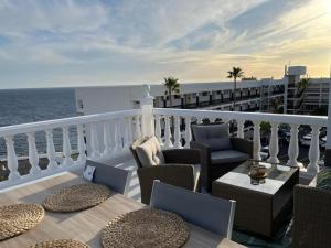 a balcony with chairs and tables and the ocean at aguaviva experience premium apartment in Callao Salvaje