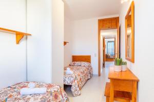 Habitación de hotel con 2 camas y mesa en Can Vidal Cabrera, en Ses Salines