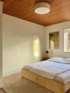 a bedroom with a large bed with a wooden ceiling at Stoksholmene13 in Svebølle