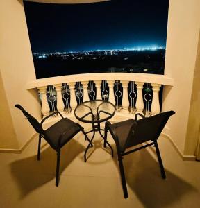 a balcony with a table and chairs in front of a window at luxury home royal breeze in Ras al Khaimah