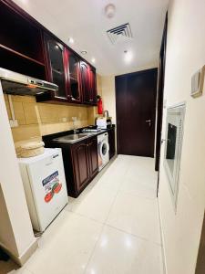 a small kitchen with a stove and a refrigerator at luxury home royal breeze in Ras al Khaimah