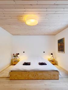 a bedroom with a large bed with a light on the ceiling at Stoksholmene13 in Svebølle