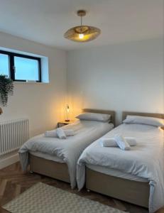 a bedroom with two beds and a chandelier at Coastal Retreat, Torquay - Anstey Cottage in Torquay