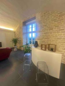 a living room with a brick wall and a window at Loft de charme avec terrasse et jardin au Fort d’Asfeld in Sedan