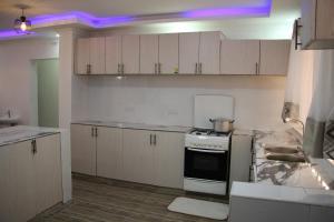 a kitchen with white cabinets and a stove top oven at TYGAJ HOME in Nakuru