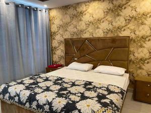 a bedroom with a bed with a black and white blanket at 3 bed Luxurious Apartment DHA PH8 in Lahore