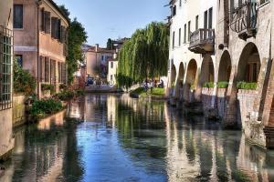 a river between two buildings in a city at Appartamento bilocale tra Venezia e Treviso! in Quarto dʼAltino