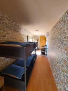 a room with two bunk beds in a brick wall at Panzio A mi Paradicsomunk in Véménd