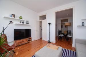 a living room with a large flat screen tv at Casa Tejo in Cruz Quebrada