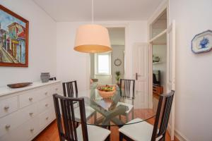 a dining room with a glass table and chairs at Casa Tejo in Cruz Quebrada