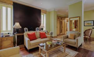 焦特布爾的住宿－The Ajit Bhawan - A Palace Resort，客厅配有沙发、两把椅子和一张桌子