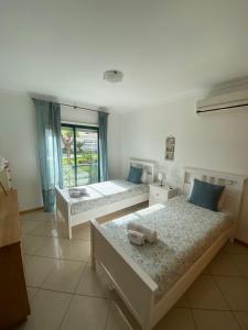 a bedroom with two beds and a window at Jardins de Santa Eulália By Albufeira Rental in Albufeira