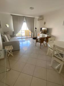 uma sala de estar com um sofá e uma mesa em Jardins de Santa Eulália By Albufeira Rental em Albufeira