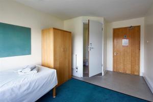 1 dormitorio con cama, armario y puerta en Frances Gardner en Londres