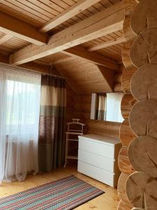 Habitación con techo de madera, cama y ventana en Cottage Simka en Mykulychyn
