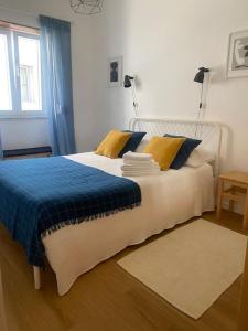 a bedroom with a large bed with blue and yellow pillows at The Green Gate Patio House in Nazaré
