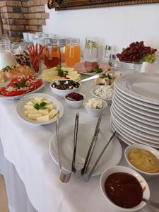 stół z talerzami i miskami z jedzeniem w obiekcie Filip Pokoje - Osłonino nad zatoką w mieście Osłonino