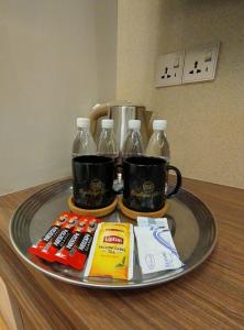 a tray with bottles and cups on a table at MS Hotel Kuala Lumpur in Kuala Lumpur