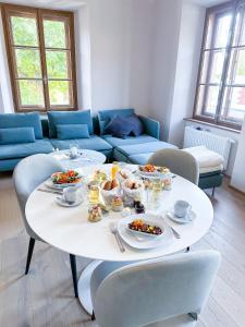 einen Tisch mit Teller Essen darauf im Wohnzimmer in der Unterkunft Das Torhaus in Feldbach