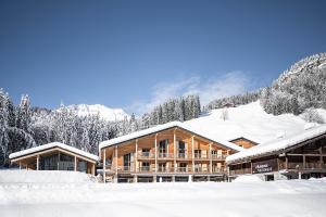 a lodge in the snow with snow covered trees at L'Auberge Nordique in Le Grand-Bornand