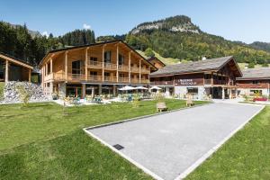 a large building with a park in front of it at L'Auberge Nordique in Le Grand-Bornand