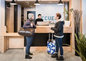 two people standing in front of a cash register at L'Auberge Nordique in Le Grand-Bornand