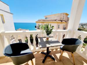 a balcony with a table and chairs and the ocean at Great Townhouse 400m from the beach in Benalmádena