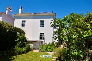 Una casa blanca con un faro encima. en Arden Villa, sleeps 8, moments from the golden sandy beach of Ryde en Ryde