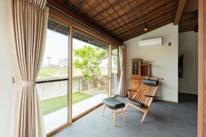 Habitación con silla y ventana en 十八楼離れ 宿いとう, en Gifu
