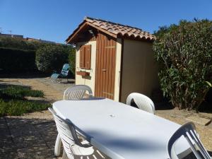 einen Tisch und Stühle vor einem kleinen Schuppen in der Unterkunft St Cyprien Maison de vacances climatisée avec jardin in Saint-Cyprien