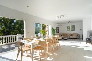 a dining room and living room with a table and chairs at Modern villa with private pool in Mijas