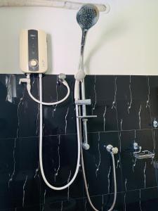 a shower with a shower head on a wall at Chill House safari resort in Udawalawe