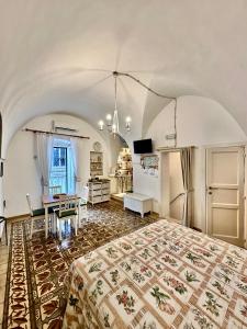 a bedroom with a bed and a table and a kitchen at Casetta Giorgia in Ostuni