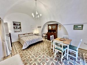 オストゥーニにあるCasetta Giorgiaのベッドルーム1室(ベッド1台、テーブル、椅子付)