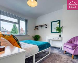 um quarto com uma cama, uma cadeira e uma janela em B24 Stunning Contractor House with 3 bedrooms, drive for 2 vehicles & smoking area in garden em Birmingham