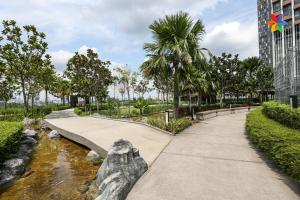 a walkway in a park next to a river at Lumi Tropicana By LilyandLoft in Petaling Jaya