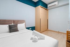 a bedroom with a white bed and a cabinet at Colony by Infinitum - 10mins to LRT Station in Kuala Lumpur