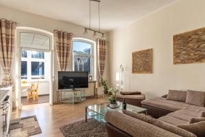 un salon avec un canapé et une télévision dans l'établissement Villa-Seiler-in-Binz-3-Raum-Ferienwohnung-Nr-5-Toplage-wenige-Schritte-zum-Strand, à Binz