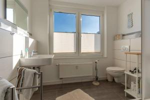 La salle de bains est pourvue d'un lavabo, de toilettes et de 2 fenêtres. dans l'établissement Villa-Seiler-in-Binz-1-Raum-Ferienwohnung-Nr-6-Toplage-wenige-Schritte-zum-Strand, à Binz 4 autres photos
