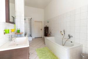 une salle de bain blanche avec une baignoire et un lavabo dans l'établissement Villa-Seiler-in-Binz-3-Raum-Ferienwohnung-Nr-5-Toplage-wenige-Schritte-zum-Strand, à Binz 12 autres photos