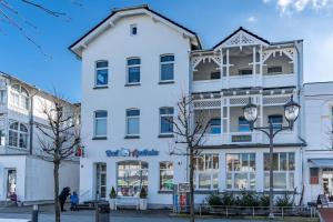 un bâtiment blanc dans une rue d'une ville dans l'établissement Villa-Seiler-in-Binz-1-Raum-Ferienwohnung-Nr-6-Toplage-wenige-Schritte-zum-Strand, à Binz