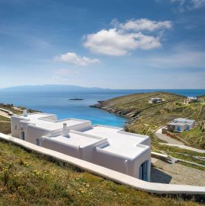 a white building on a hill next to the ocean at VILLA AGAPI KYTHNOS in Agios Dimitrios
