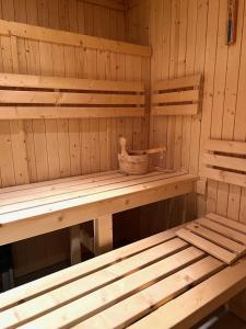 a sauna with a wooden bench and a bowl on it at La Closerie SPA & Résidence Hôtel in Deauville