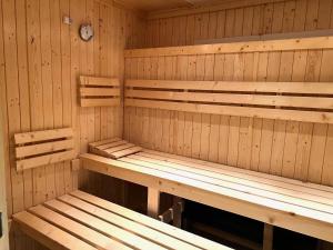 a sauna with wooden benches and a clock on the wall at La Closerie SPA & Résidence Hôtel in Deauville