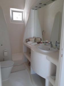 a white bathroom with a sink and a toilet at VILLA AGAPI KYTHNOS in Agios Dimitrios