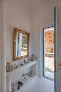 a white bathroom with a mirror and a sink at VILLA AGAPI KYTHNOS in Agios Dimitrios